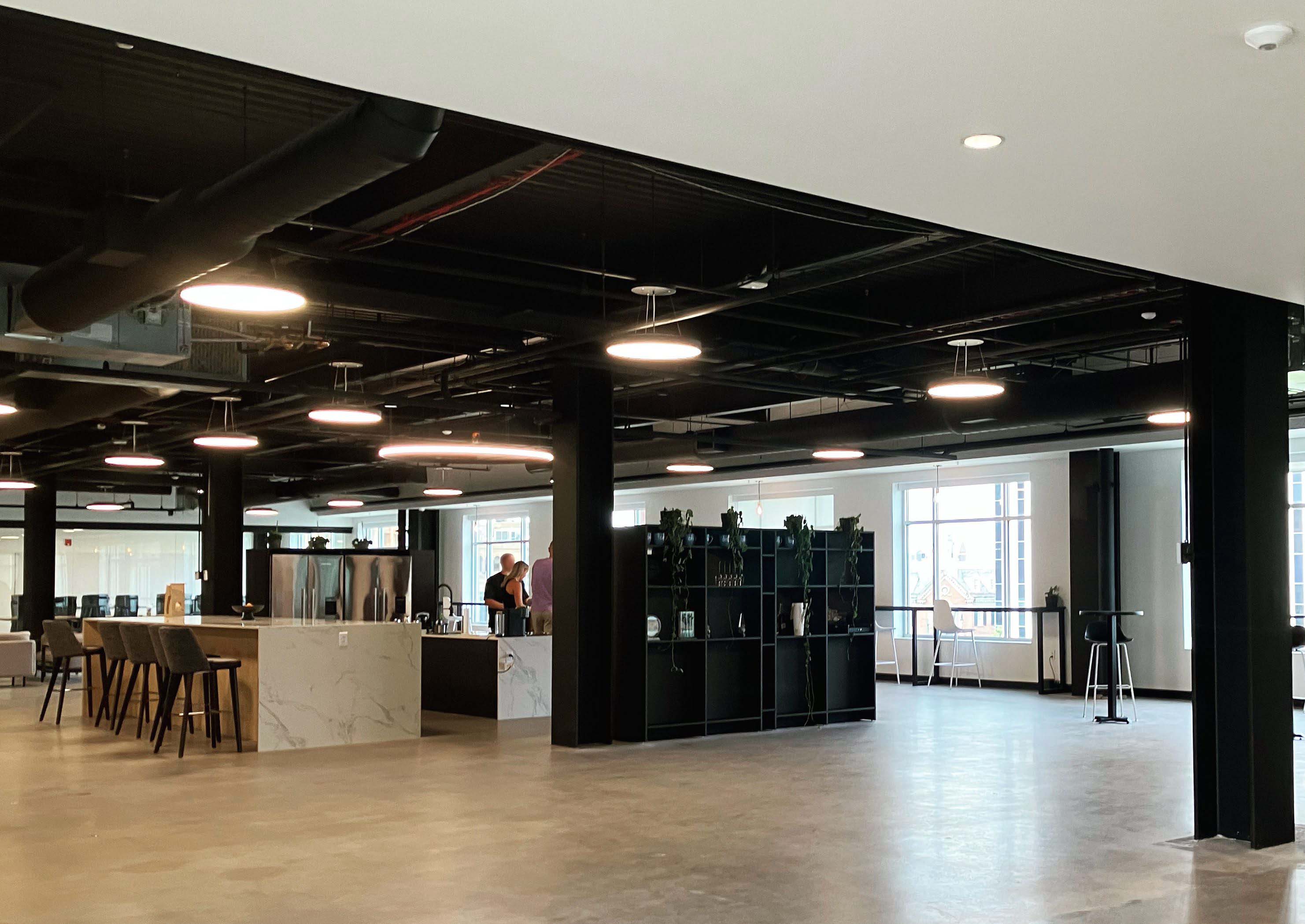 Photography of FTS kitchen space, with granite hi-top, and stainless steel fridges