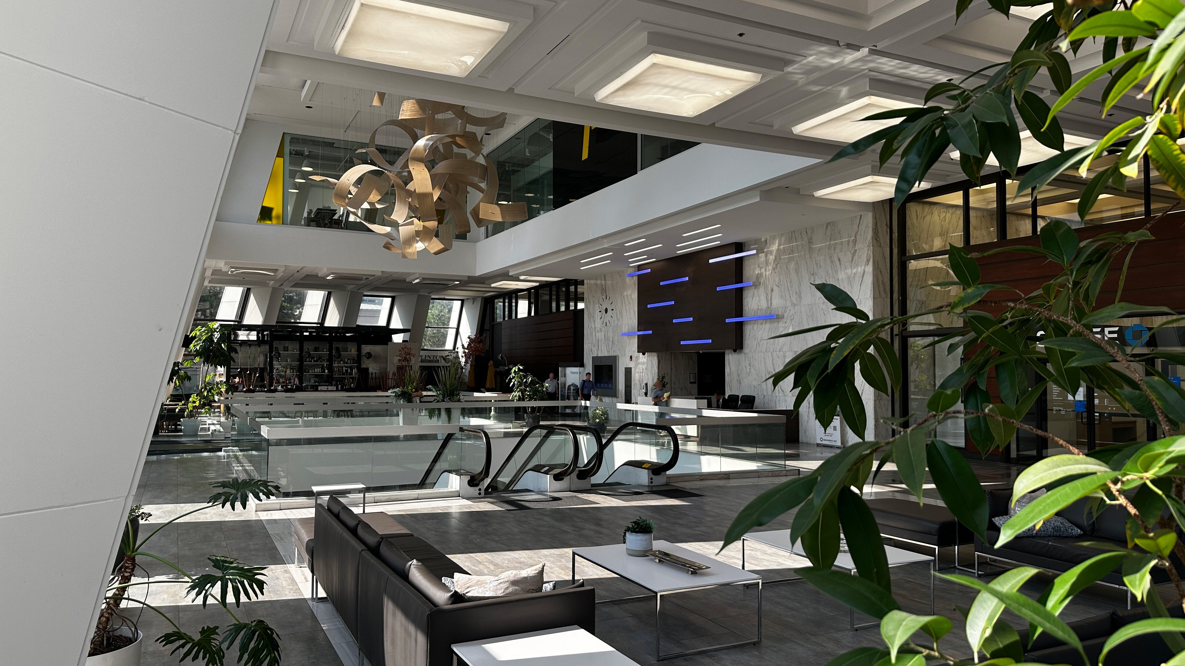Lobby of the metropolitan building, filled with foliage, lighting and a 3 story central area