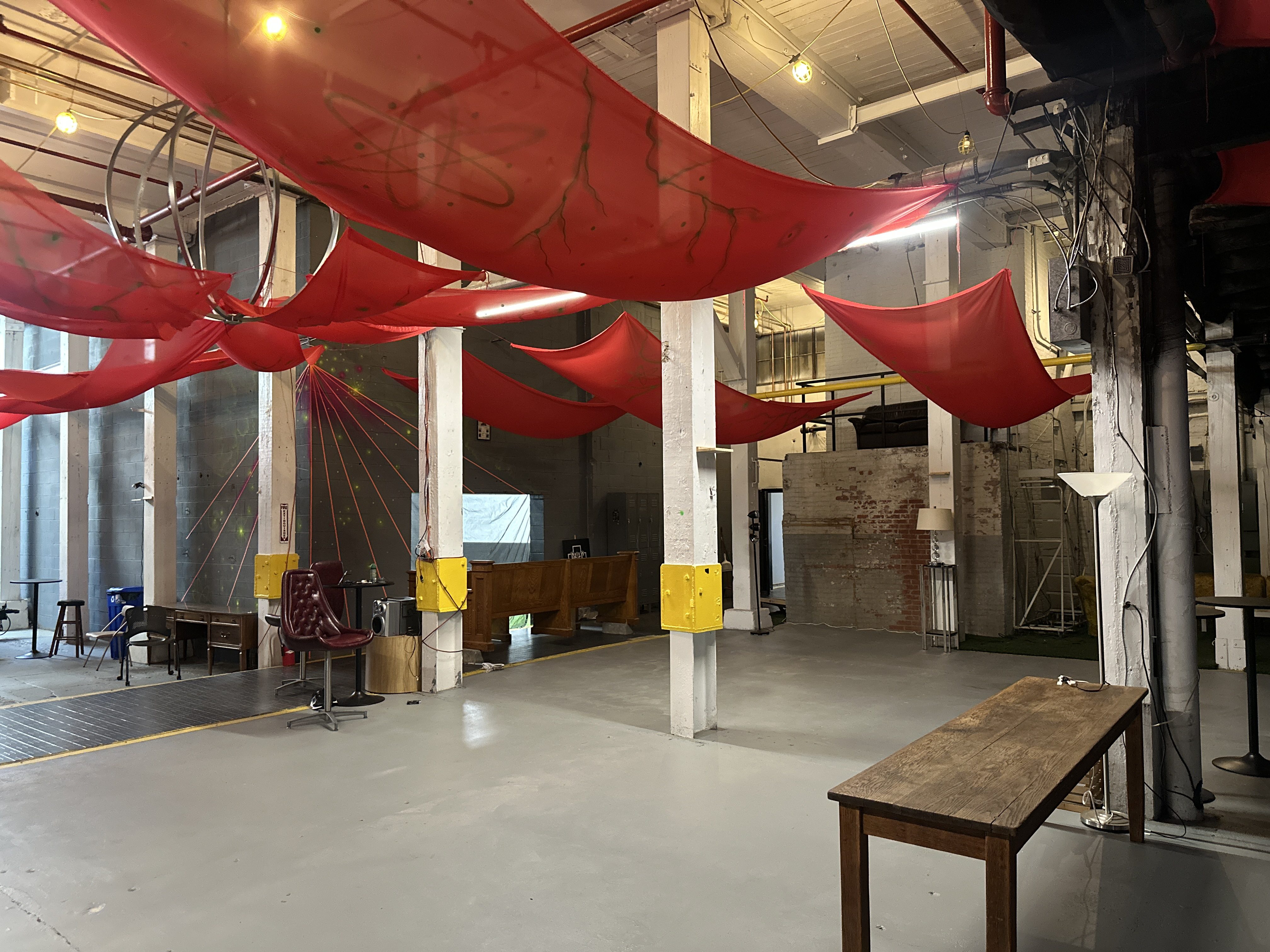 Lounge space of the Fedder, fleeting crimson tarpaulins topping a spacious dance floor