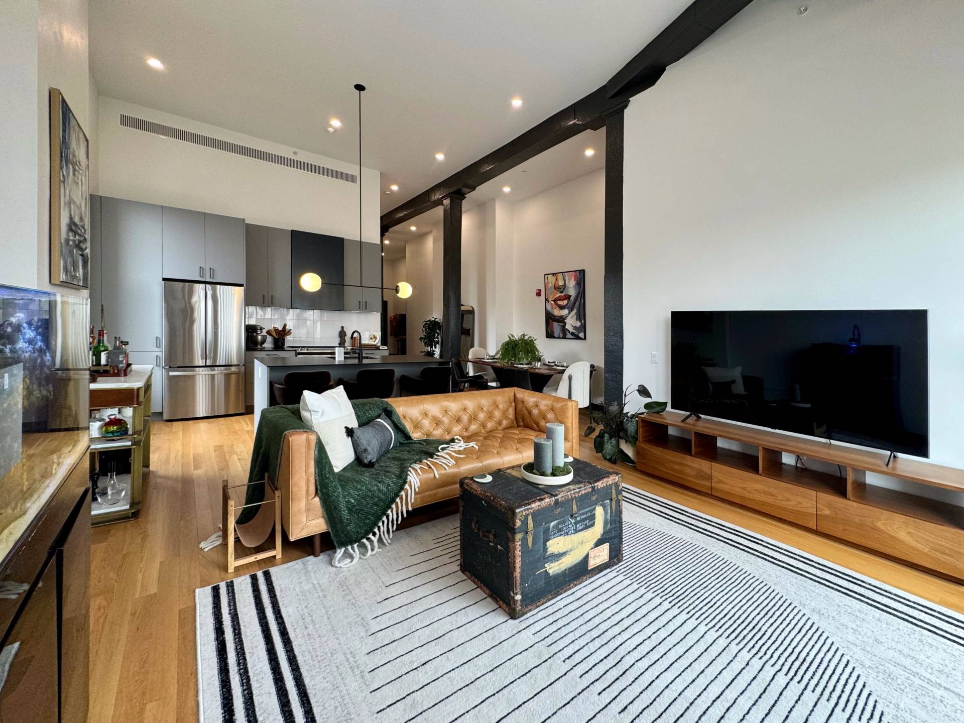 Interior of glenny building unit, large kitchen and living room space with leather couch