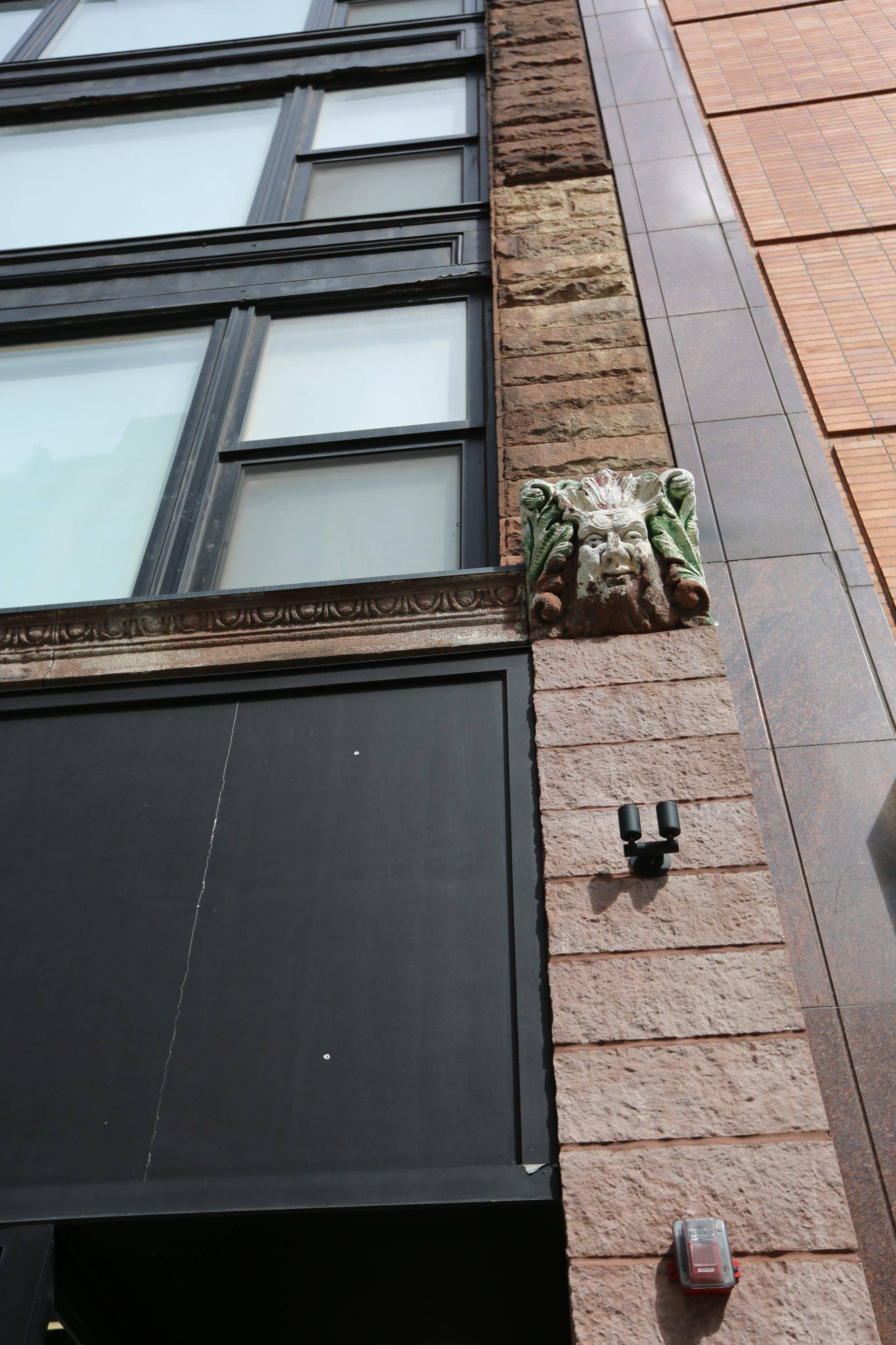 Exterior facade of Glenny building, cornice, sculpted face corner head 